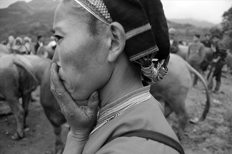The women quietly listen to the bargaining between men.