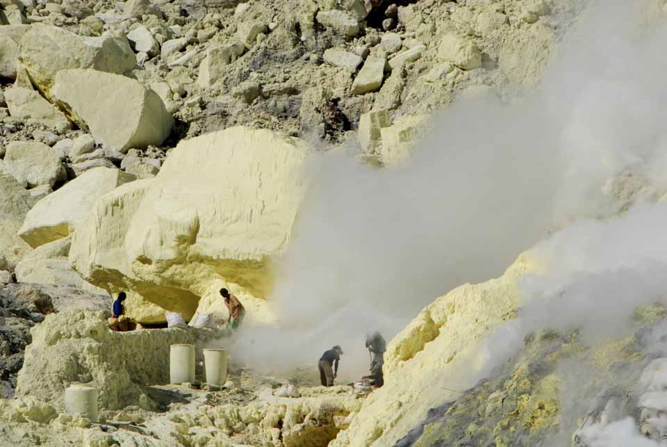 Risking diseases of the lungs, heart and eyes, miners extract pure sulphur as it emerges in molten form from deep within the crater