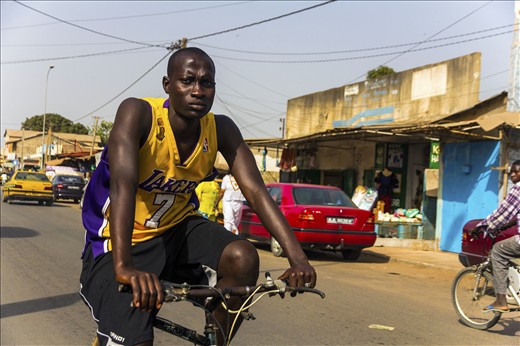 a young African man cycling around the neighborhood in  Serrekunda, The Gambia