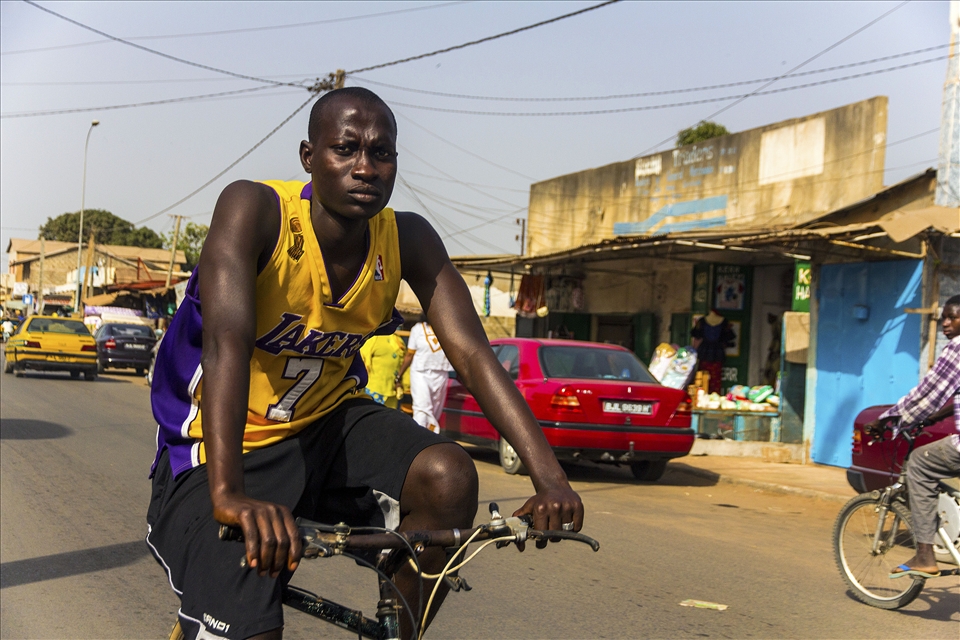 a young African man cycling around the neighborhood in  Serrekunda, The Gambia