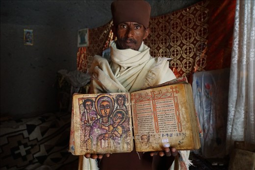 Priest holding 300 yr old Marian book