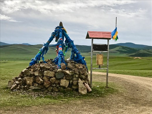 Shamanic shrine and Buddhist prayer wheel at the top of a pass