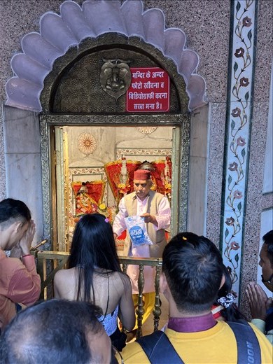 Priest handing out Prasad at Naini Devi Temple