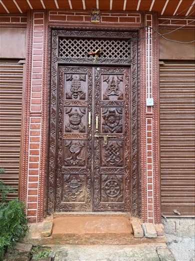 door with eight auspicious symbols in newly renovated house in Sankhu - the village was badly damaged in the 2015 earthquake