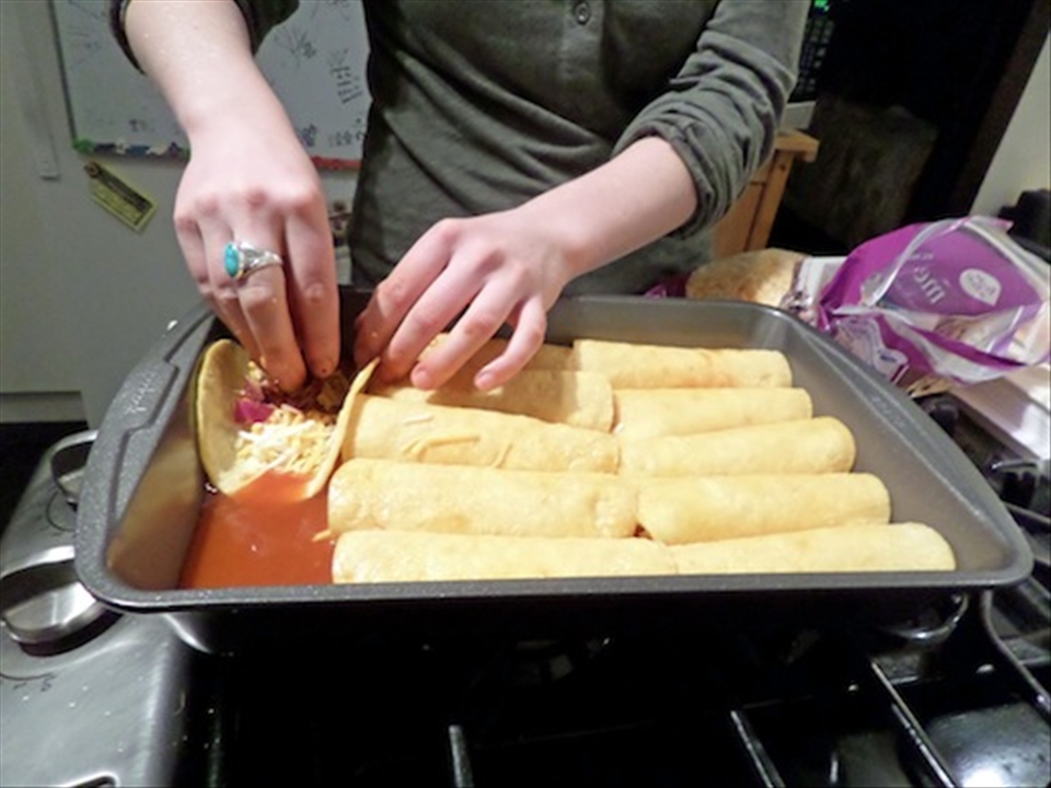Filling enchiladas with cheese, chiles, chipotle peppers, onion, and love.