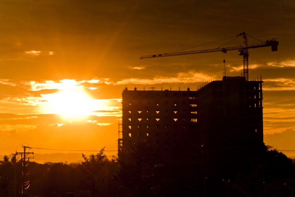 Towering crane and building over the fast growing city of Davao. It's silhouette symbolizes the empowered transformation of the old urban jungle.