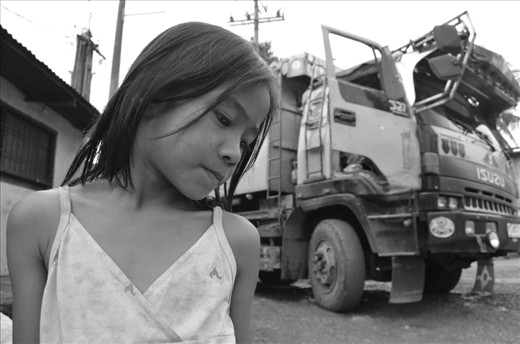 SENSE OF HEARING. A young girl on the street of Payatas—a slum area in urban Quezon City—hears the bell of an incoming dump truck. This is a signal of an arrival of a 
new bunch of 'treasure' – a pile of garbage which is a probable source of their 
meals for the day. Families earn money by selling items to nearby junk shops.