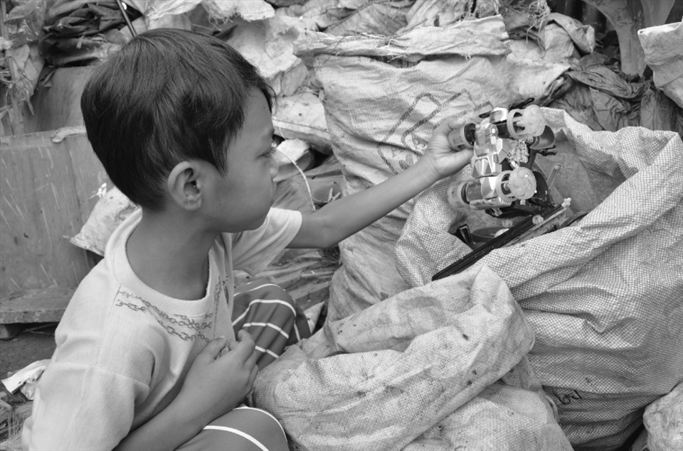 SENSE OF TOUCH. A young boy finds a toy car in a sack of segregrated trash. Instead 
of purely enjoying their childhood, the kids are already taught how to find 
reusable items from mounds of filthy garbage. They have to learn to rummage using 
their hands in order to get more money for the family.