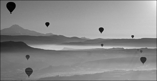 Hot air balloons rise with the sun in Cappadocia, Turkey