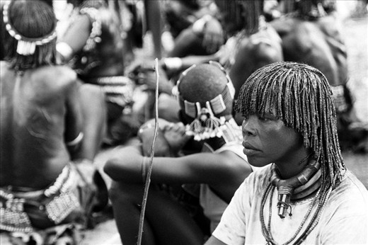 The mother of the boy takes a moment of quiet between the celebrations.