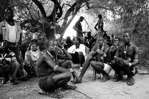 The Maza, men who have already come of age, wait in the shade holding switch sticks.  Women of the tribe will approach and goad the Maza into whipping them.