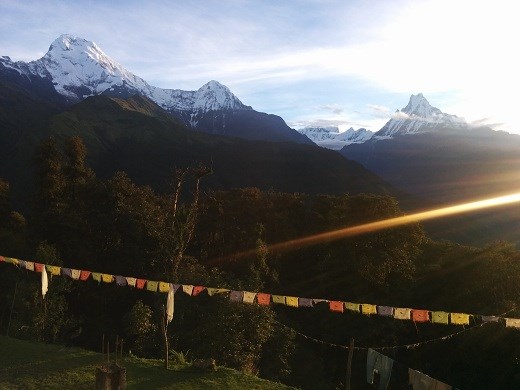 Sunrise over the Annapurna mountains with prayer flags illuminated by light. 