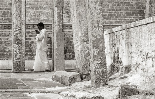 Over a million devotees visit the sacred stupa related places in Anuradhapura, Sri Lanka. Especially during “Full moon Poya” days such as “Poson ”. Stupa’s are strong and inspiring pieces of architecture, drawing to them different people from different walks of life. They all have one thing in common, that is “Hope”.  It is true even with this devotee, who is Circumambulating the “Ruwana Weli Maha Stupa”. 
As he emerges through all the rough textures, you feel that - by and large “Hope” comes into play when our circumstances are “dire”.
