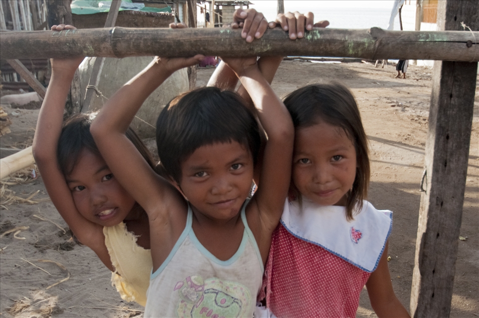  Local girls from Pandanon watch as visitors walk through  the island town.