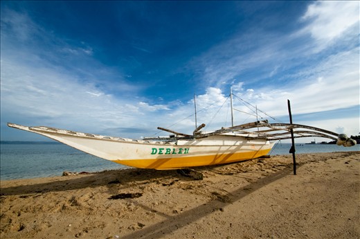 a banca boat is docked on the shores of Pandanon Island in the Philippines.
