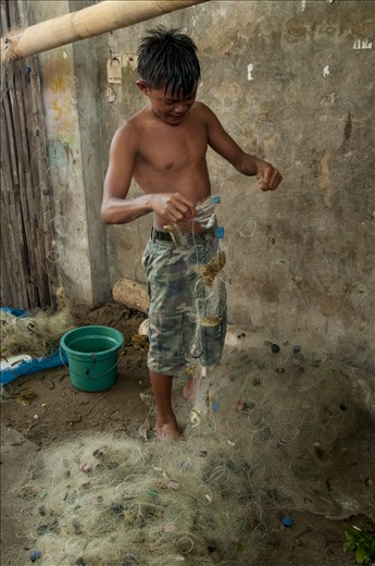 A local fisherman on Pandanon  going through his net at sunset.