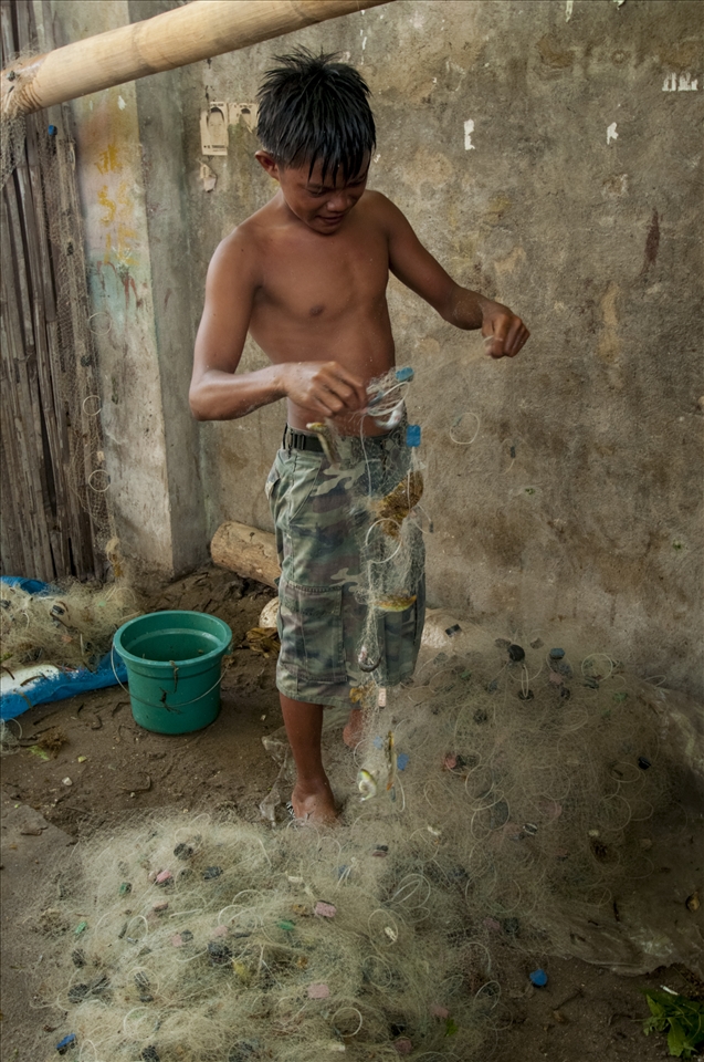 A local fisherman on Pandanon  going through his net at sunset.