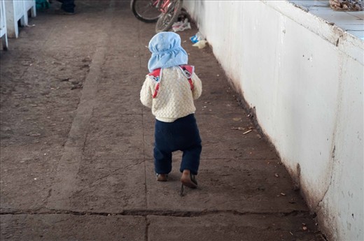 A young boy playing and running in the market isles. San Pedro Markets, Cuzco, Peru. 