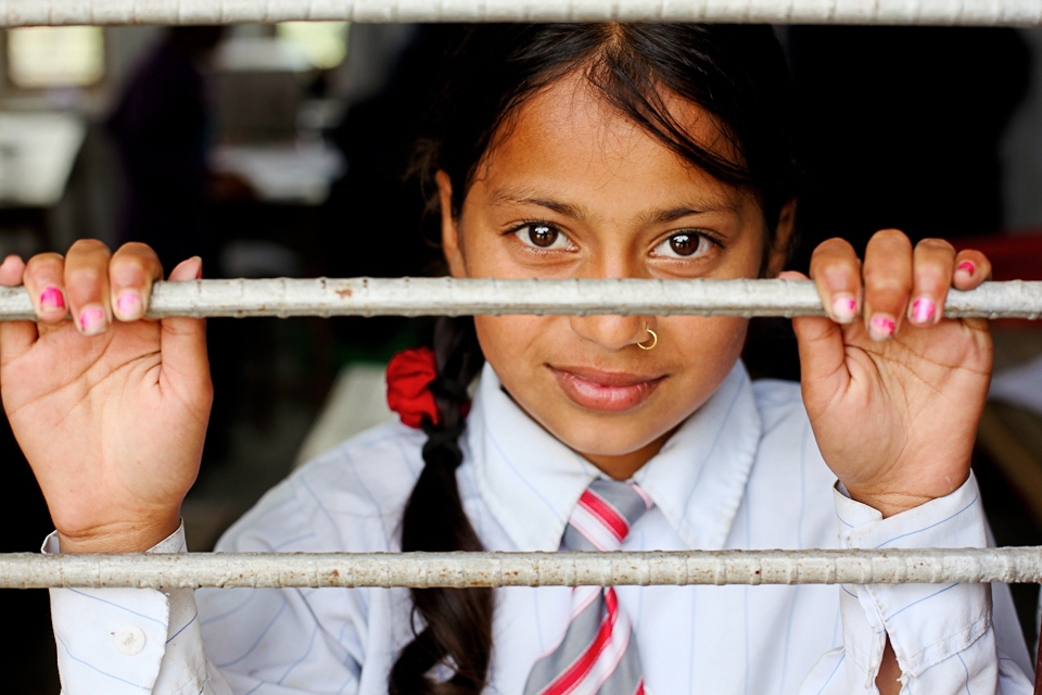 A girl in her final year of school looks out of the window at the world beyond. Every classroom of the world has room for one day-dreamer.