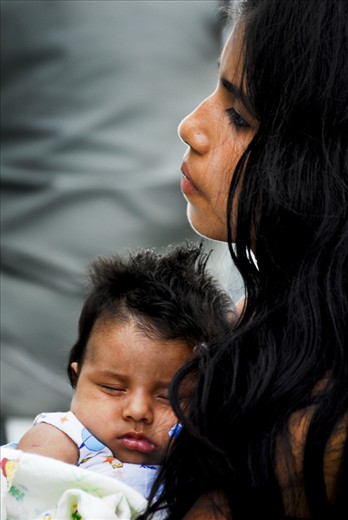 A young mother and child share a quiet moment as they journey on one of three cargo ships which make their way up the Peruvian Amazon from Iquitos just a few times each month. 