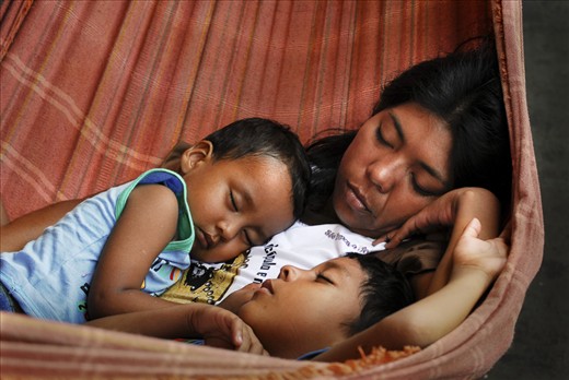 A woman naps in a hammock with her two sons. They are in one of hundreds of hammocks crowded together to accommodate passengers travelling up the Amazon on cargo ships, which carry everything from building supplies and livestock, to government-issued condensed milk in tins destined for some of Peru's most remote villages.