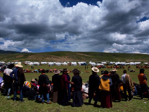 The crowds gather in two long rows on each side to mark the race track.