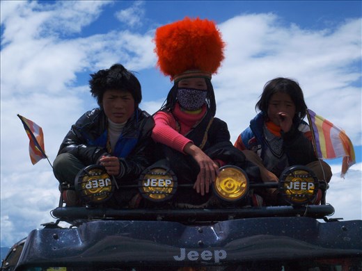 Children gather on the roofs of Jeeps, to see over the crowds and watch the race
