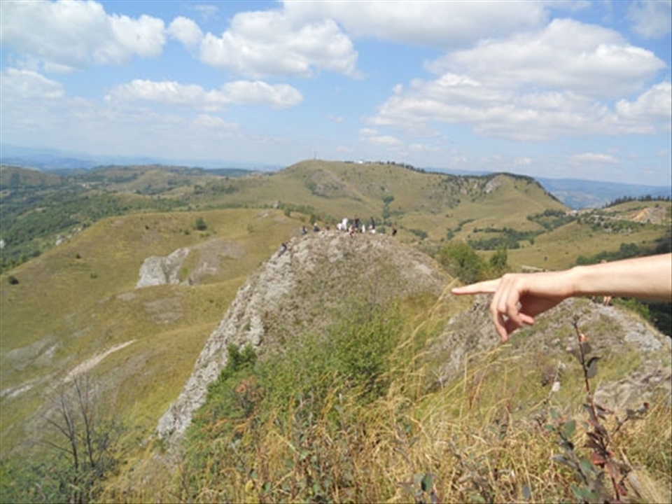 Rosia Montana with its existence of almost two millennia is a mining village in Transylvania, subject to high controversy due to a mining project owned by a gold-hunting Canadian company.  NGOs and private people unite their forces to preserve the ancient village and to make it a UNESCO World Heritage site. Once a year, they organize FanFest (Hay Festival) to make people aware of the beauty that this area holds and that tourism could be a worthy choice for the people in Rosia Montana. I managed to take a shot with the hand of our guide, also a volunteer, who was showing us the village from the top of a mountain. In the back, there is another group of visitors enjoying the beautiful vista that the rich Rosia Montana gives for free.