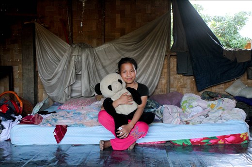 The kids of Pho Kham seem to have a very happy upbringing full of love and fun and devoid of the kinds of things western kids complain about. There is no such thing as boredom- they spend a few hours each morning at school, getting out around 11.30 and after lunch spend their time swimming, riding their bikes, exploring, fishing, and being fascinated by visitors. The kids do help on the farms and around the house when asked but have a lot of freedom. When I asked Nola about toys, she proudly produced her favourite teddy bear. Here she poses with him on the bed she shared with the rest of her family.