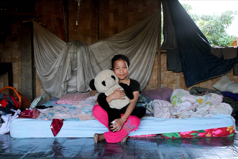 The kids of Pho Kham seem to have a very happy upbringing full of love and fun and devoid of the kinds of things western kids complain about. There is no such thing as boredom- they spend a few hours each morning at school, getting out around 11.30 and after lunch spend their time swimming, riding their bikes, exploring, fishing, and being fascinated by visitors. The kids do help on the farms and around the house when asked but have a lot of freedom. When I asked Nola about toys, she proudly produced her favourite teddy bear. Here she poses with him on the bed she shared with the rest of her family.