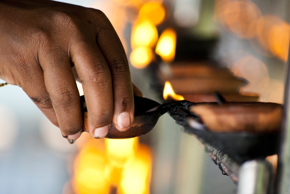 A devotee lights a lamp at the Temple. Light is said to be a symbol of wisdom. The lighting of lamps is said to generate wisdom and dispel the darkness of ignorance.