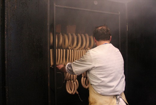 Just like the cows are aligned in the previous image - the sausages are aligned in this shot. Schüll III. puts them in the 
„Räucherkammer“ (smokehouse) to achieve the smokey taste he wants. Doing it the same way as his father and his grandfather, soon, his son will follow. The butchery will carry on for a fourth generation. Every generation has a different story to tell, closely connected to German history. The only constant between the generations is the meat and the given name „Schüll“. 