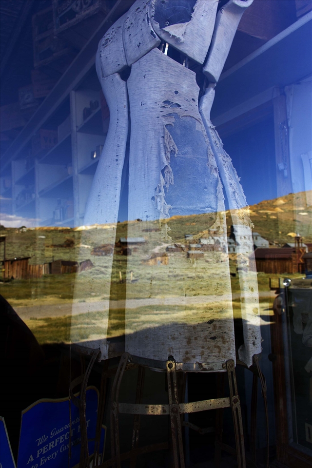 Dress shop, with the closed gold mine in the window reflection. 