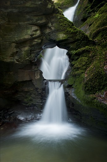 'Angel's Well', shot in Cornwall, The United Kingdom. This shot was the result of standing in icy water for over 90 minutes. I discovered this waterfall quite by chance. Hidden at the end of a long woodland walk in an overlooked valley, this waterfall is nothing short of beautiful. With only a prime lens attached to my camera, to achieve this shot I had to bear the bitterly cold spray and set up camp in the icy water. It took over an hour and a half to wait for the right cloud coverage to soften the light and paint this scene. Despite not being able to walk properly due to my feet turning a white shade of blue this photograph was worth all the effort. 