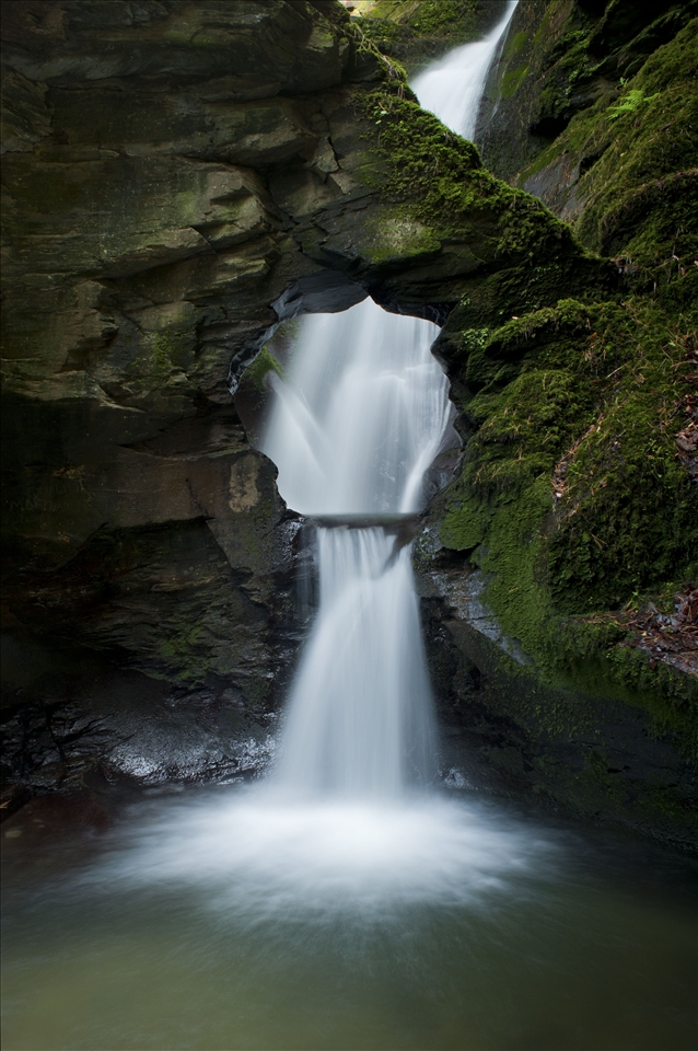 'Angel's Well', shot in Cornwall, The United Kingdom. This shot was the result of standing in icy water for over 90 minutes. I discovered this waterfall quite by chance. Hidden at the end of a long woodland walk in an overlooked valley, this waterfall is nothing short of beautiful. With only a prime lens attached to my camera, to achieve this shot I had to bear the bitterly cold spray and set up camp in the icy water. It took over an hour and a half to wait for the right cloud coverage to soften the light and paint this scene. Despite not being able to walk properly due to my feet turning a white shade of blue this photograph was worth all the effort. 