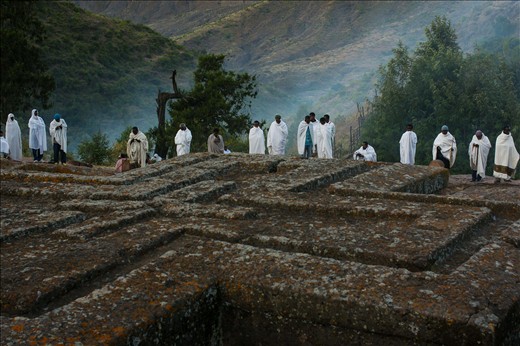Perched high in the mountains of Northern Ethiopia, the small town of Lalibela is a place of pilgrimage during the time of Orthodox Christmas, and Ethiopian Christianity's second holiest site. Wrapped in shrouds of early morning mist and cotton, Ethiopian Orthodox Christians stand in prayer at the edge of Bet Giyorgis, the rock church carved to resemble a cross.