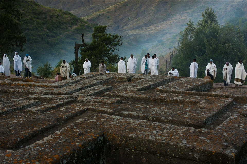 Perched high in the mountains of Northern Ethiopia, the small town of Lalibela is a place of pilgrimage during the time of Orthodox Christmas, and Ethiopian Christianity's second holiest site. Wrapped in shrouds of early morning mist and cotton, Ethiopian Orthodox Christians stand in prayer at the edge of Bet Giyorgis, the rock church carved to resemble a cross.