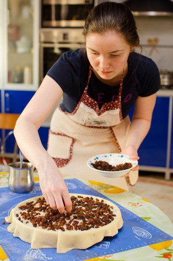 Covering a pie with last layer of raisins
