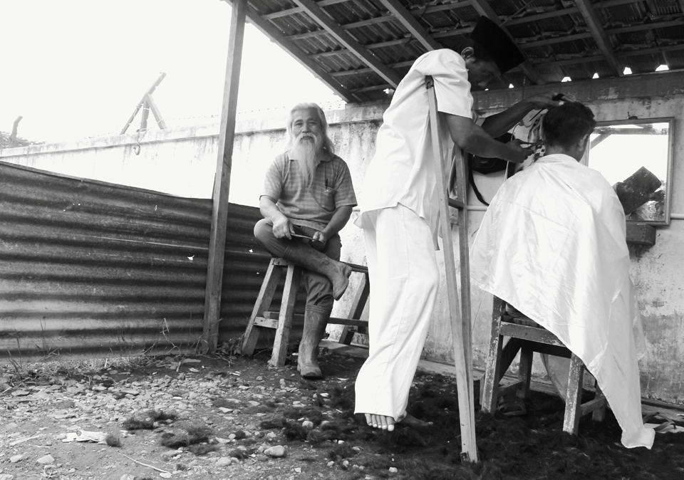A little barber tent is opened at the corner of the market. It's quite a busy day for the barber because market day is at every five days, so when it's a Sunday, lots of people will come over to have a nice clean hair cut. People will know that this is a good barber based on the amount of hair left over on the ground.