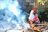 Mrs. Nik and her son, Rofiq, waits in the shades while Mr. Nik works on burning the remaining cane plants after the harvest.: by lieshabear, Views[742]