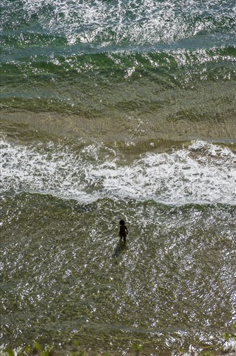 Challenging the waves. Gaeta. A woman is fighting the heat of the beginning of September taking a bath in the Mediterranean Sea. Gaeta is one of the few spots in Latium where it is still possible to find clear water.