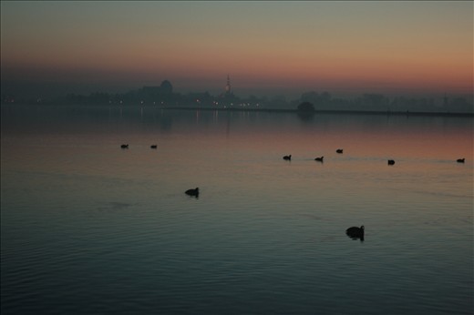 Het Veerse meer in the middle of the winter. The colors of the sunset and the Veerse toren vaguely but recognizable in the background creates a mysterious atmosphere