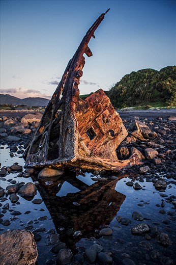 i old ship that has been rusting away on a great surfing beach