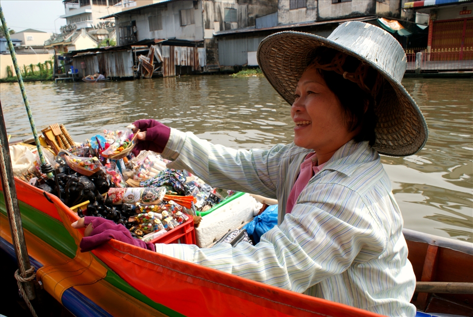 Bangkok, Thailand: salespeople flag down tourist-filled boats to sell trinkets. 