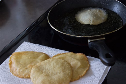 Homemade corn tortillas frying in oil, becoming what is called a 