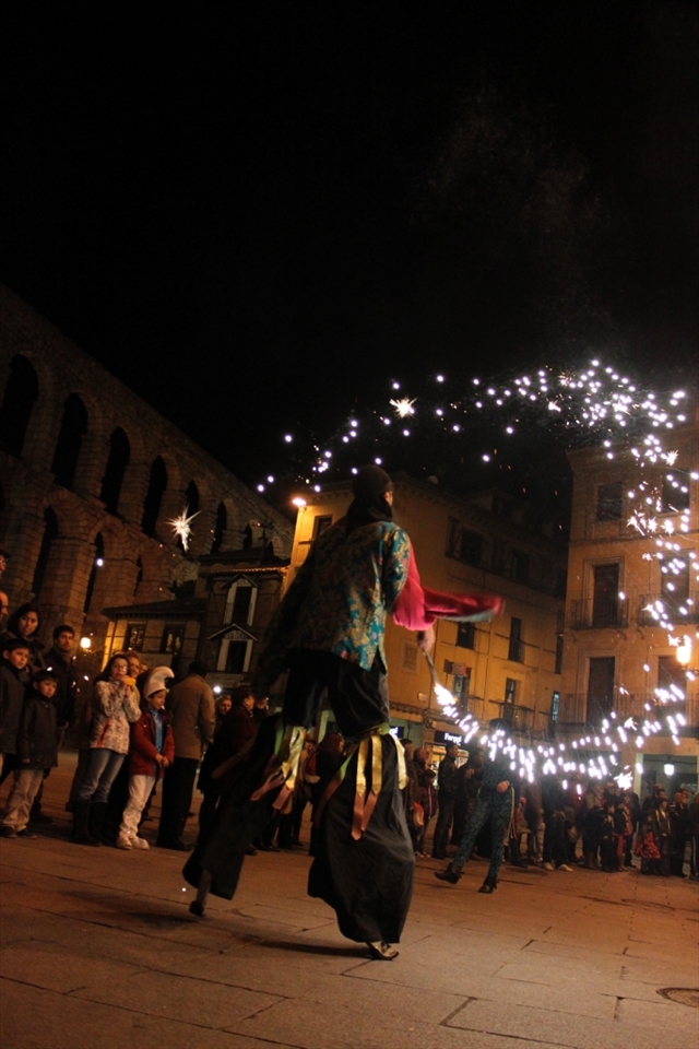 The parade's grandmaster wears stilts and pirate-esque attire while brandishing a pyrotechnic wand. 