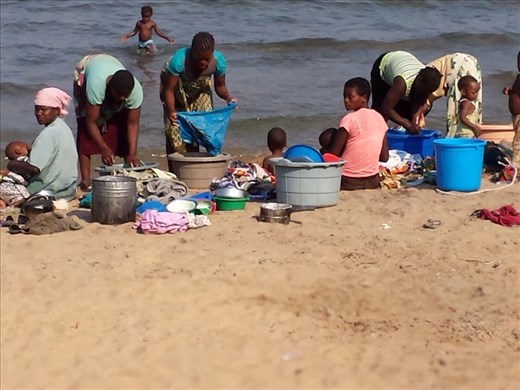 Women washing clothes and dishes, Lake Malawi 