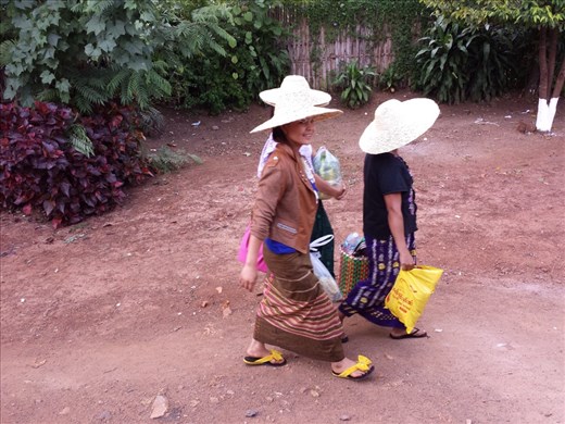Women walking by train. The yellow flip flops are the fanciest I've seen.