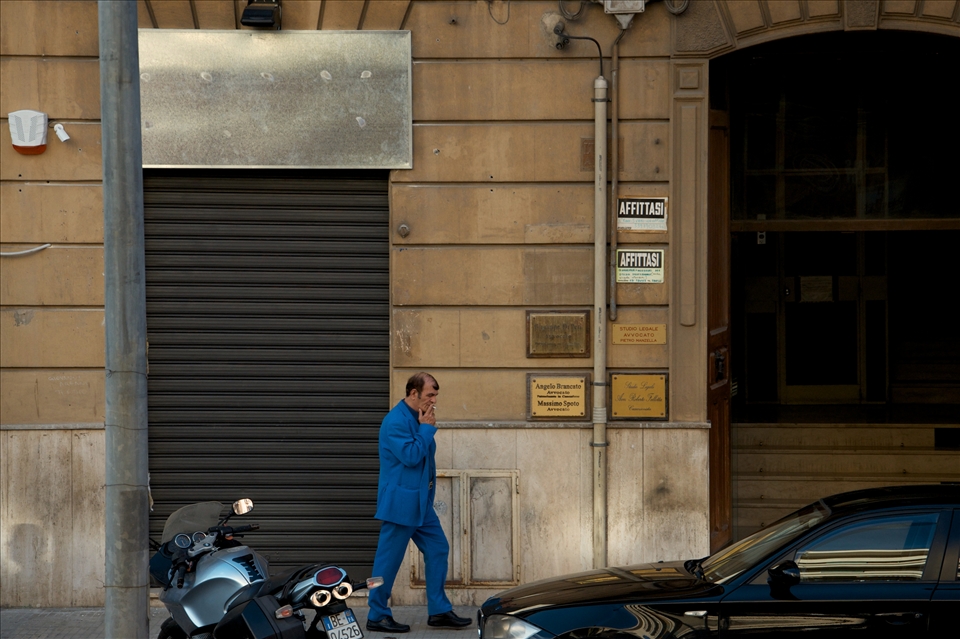 Organised crime: Disclaimer - I'm not in any way, implying that this man in the photo is involved in organised crime of any sort. However, what I am trying to portray is that there is a seedier, shady side to Sicily, that many people don't like to acknowledge or discuss. To me (and my sometimes over active imagination), the colour of the suit, the cigarette in the mouth and the comb over of the hair, remind of something akin to a pimp. Meanwhile, this guy is walking past a building that has several signs for 'affitasi', 'avvocato' and 'studio legale' which translate to 'for rent', 'lawyer' and 'legal studio'. I couldn't help but take a photo - it makes for an interesting story whatever way you (and your overactive imagination) look at it. 