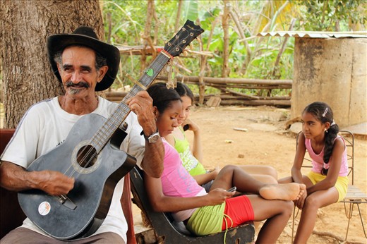 Old hands, playing music. Young hands, sending messages. Trinidad, Cuba.